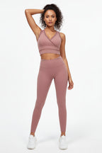Woman wearing a pink athletic outfit on a white background