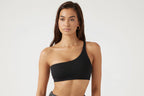 A woman wearing a black Yoga Chest Pad Top with a deep V-neckline.